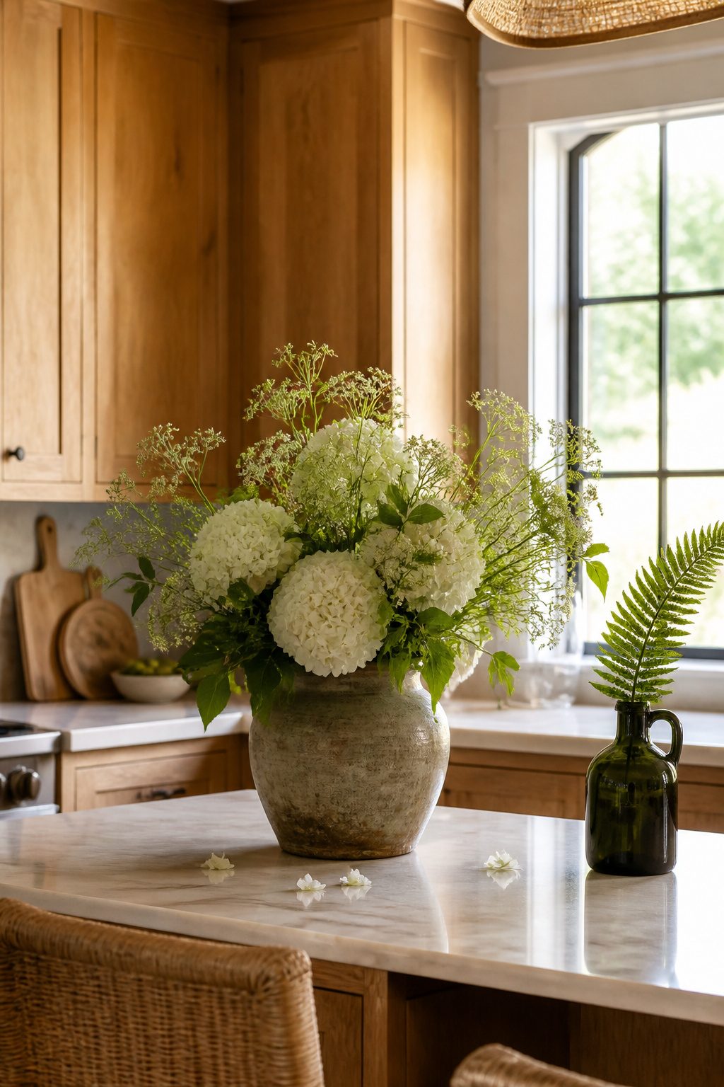 10 Summer Home Decor Inspiration Ideas for Easy Warm-Weather Style 5 A kitchen counter with fresh flowers and a vintage wine jug.